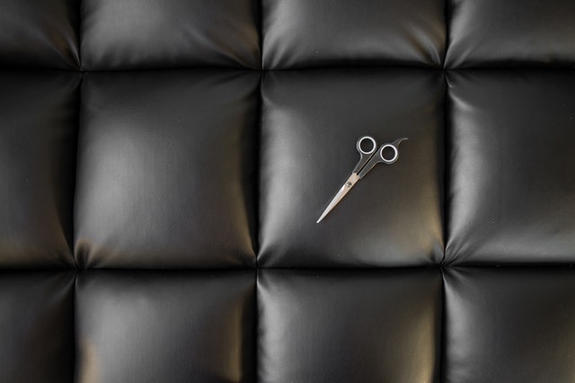 scissors on a black leather couch